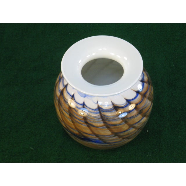 This is a Nourot art glass vase featuring a swirl pattern in cased rust and blue colors. Hand blown using glass material,...