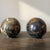 Pair of substantial polished marble decorative spheres, each featuring distinct natural coloration and veining. One sphere...