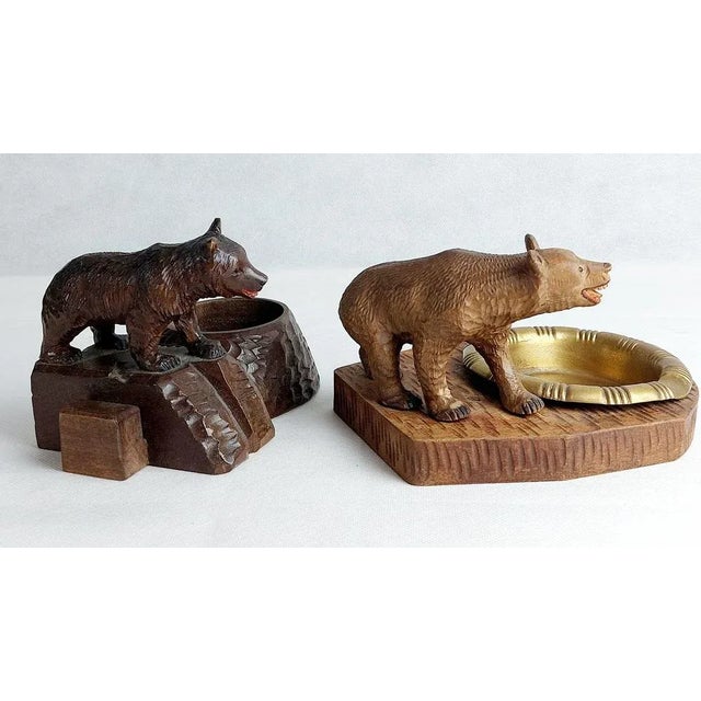 Wondelfull set of two Black forest ashtrays. One is made out of Lindenwood and the other massive wood. Both haves glass...