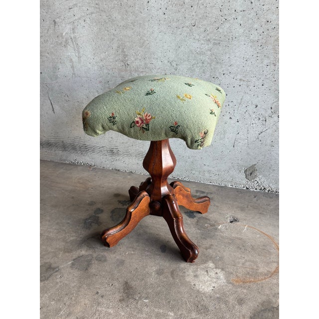 A charming antique Victorian piano stool or bench, crafted in solid carved wood and upholstered in a light green...