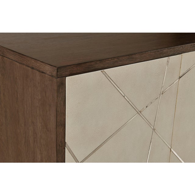 The Remi features linen colored faux shagreen door fronts inset with intersecting polished nickel metal strips to create a...