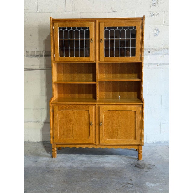 This tall oak hutch in style of Henning Kjærnulf combines enclosed and open sections in a balanced vertical form. Two...