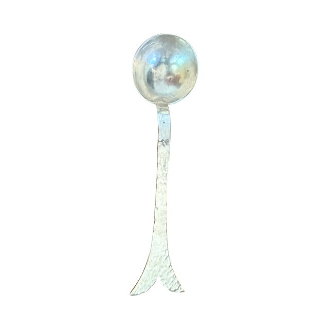 A striking vintage Mariposa Brillante hand-hammered serving ladle featuring an expressive sculptural whale-tail design...
