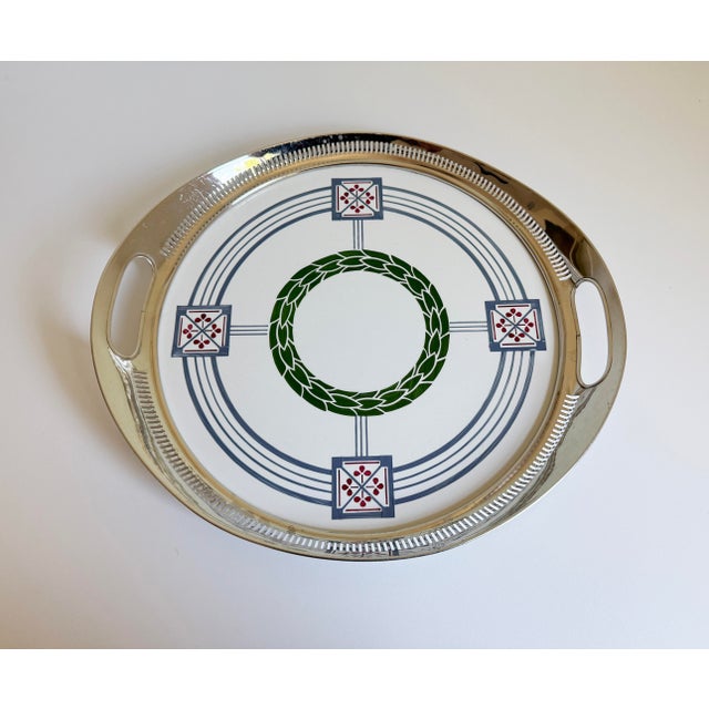Antique Secessionist serving tray crafted with a glazed porcelain insert and a polished nickel rim with two integrated...