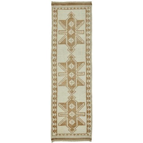 This exquisite runner rug is a rare example of tribal craftsmanship, hand-knotted by the women of the Herki tribe during...