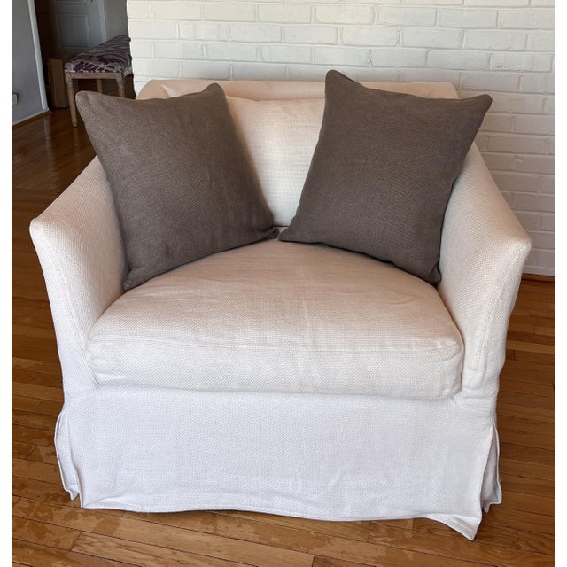 This ivory slipcovered chair by Verellen features elegant, sweeping curves that create a sculptural profile, enhanced by...