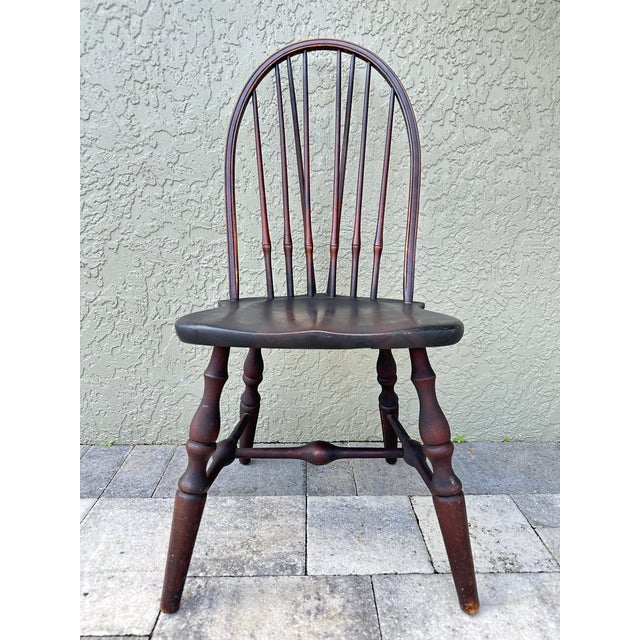 Antique Mid-19th century Windsor side chair with bow-back design and a sculpted saddle seat. Eight wooden turned spindles...