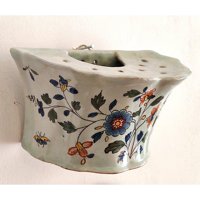 An 18th-century faience wall vase from Rouen. An antique, hanging ceramic flower vase from Rouen, one of the most...