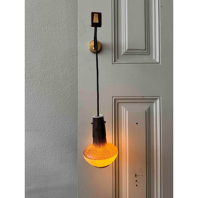 A unique Scandinavian mid-century sconce from the 1950s, featuring a charming combination of brass, wood, and glass. This...