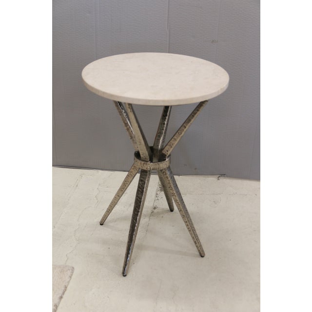 Tapering angular metal legs are joined at the center with a metal ring below a round 5/8" thick top fitted with Spanish...