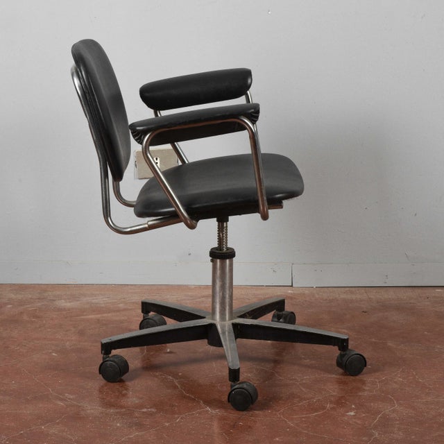 This vintage office chair is an example of functional period design, characterized by clean lines and a sturdy structure....