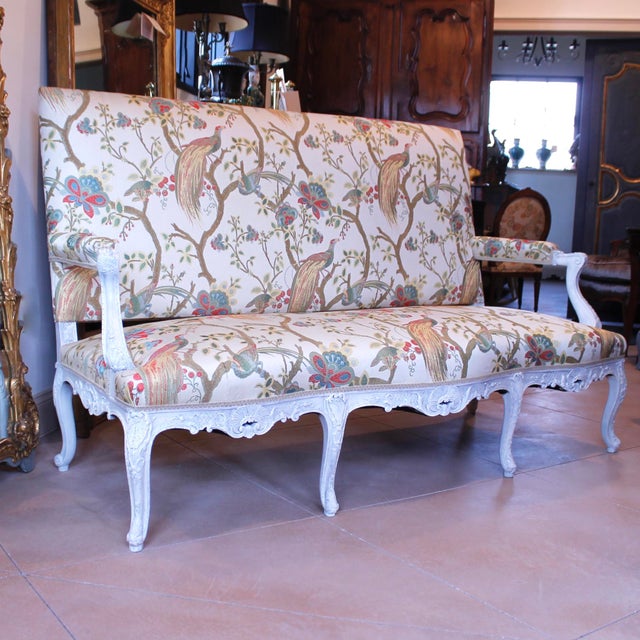 A very finely carved ca. 1890’s Régence style sofa or settee painted cream and freshly upholstered in an 18th century...