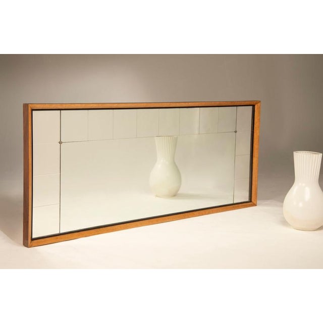 A 1940s deco-style mirror with a maple wood frame and the original mirror from that era. The mirror has a wooden frame...