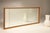 A 1940s deco-style mirror with a maple wood frame and the original mirror from that era. The mirror has a wooden frame...