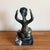 A signed bronze figural sculpture by Benjamin Kopman, mounted on a black marble base. The piece depicts a seated female...