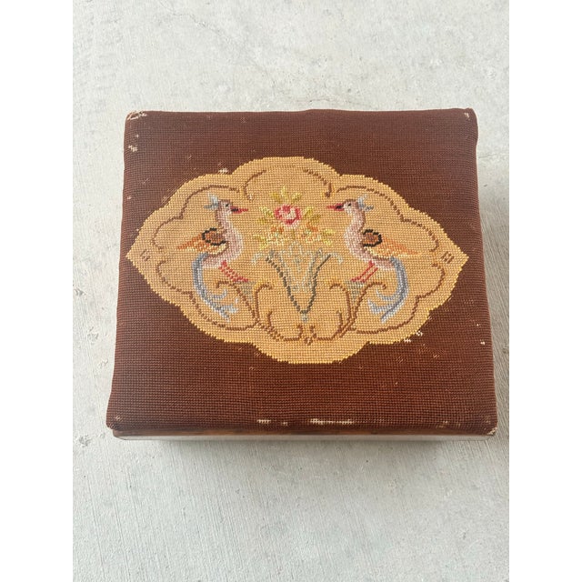 Antique needlepoint footstool with sweet birds motif on low wooden base. Dimensions: 7"h x 15"w x 13.5