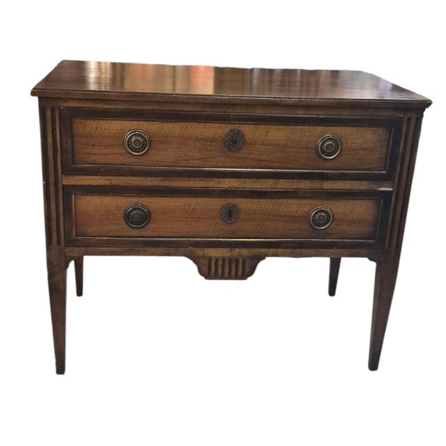 An Italian two drawer commode in the neoclassical style with square tapering legs Fruitwood with a walnut finish.