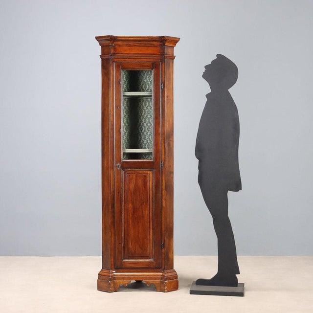 Arte Povera corner cabinet in walnut-stained fir. Glass door with a glass top and lower panel, three internal shelves, and...