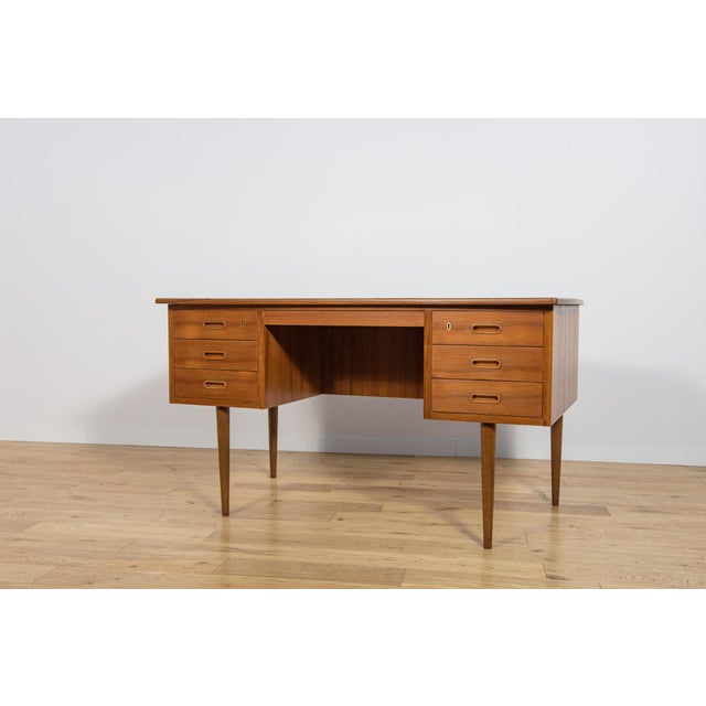 This desk was made in the 1960s by the Danish manufacturer Edmund Jørgensen. It's crafted from teak with contoured...