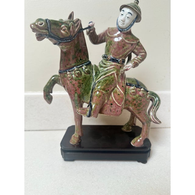 Chinese tang sancai glazed horse riding figure dominated by rich molted green and reddish brown tones