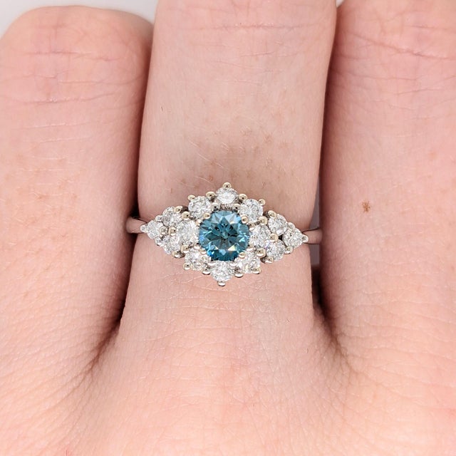 A rare blue diamond glows with a rare fancy blue at the centre of this solid 14K white gold ring. A fancy blue is among...