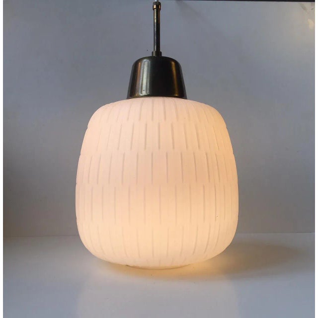 This large gourd-shaped pendant lamp is made of matte opaline glass with a brass mount and tube. The light is in the style...