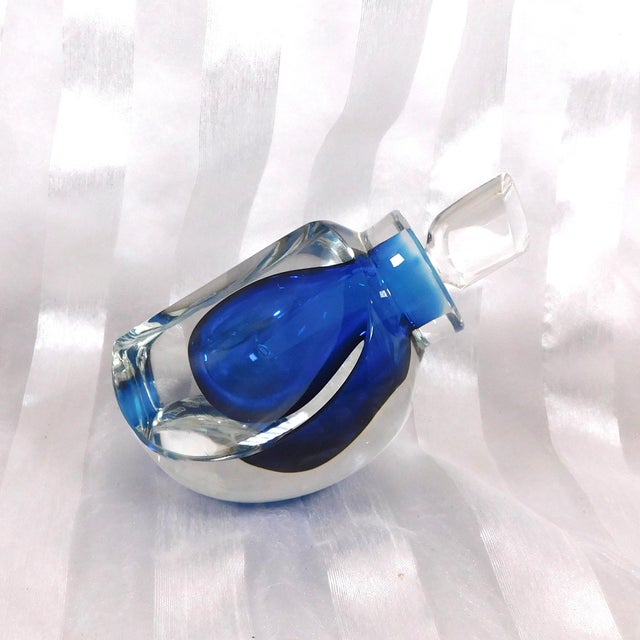 This is a Goran Ward Kosta Boda Limited Edition Signed and Numbered Perfume bottle. It is dark blue cased in clear crystal...