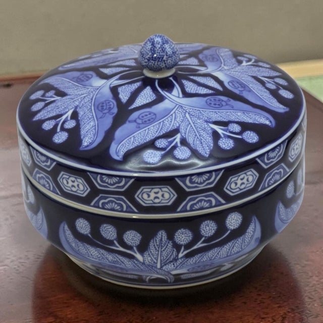 The Decorative Chris Madden Ladybugs Blue & White Leaf Floral Lidded Porcelain Jar is a medium-sized, round trinket...