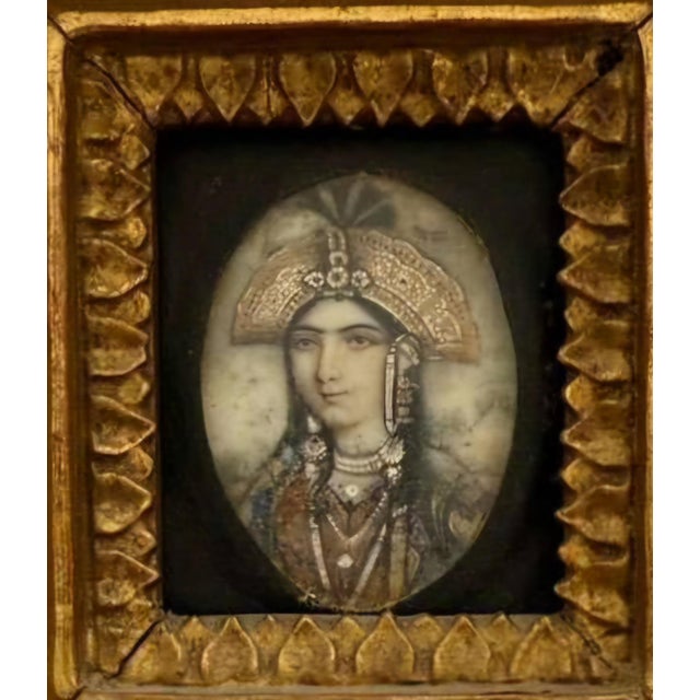 Elegant Indian miniature portrait painted on ivory, depicting a Mughal noblewoman in three-quarter profile. She wears an...