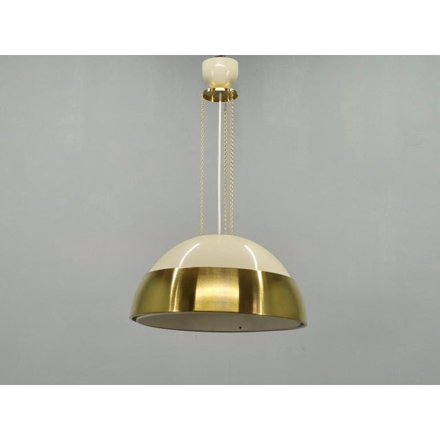 Elegant 1970s pendant light from czechoslovakia crafted in lacquered metal with a polished brass band detail. The bold...