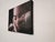 This oil on canvas piece features a close-up of a contemplative figure, their face partially obscured by hands, creating...