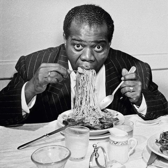 "Dinner Jazz" by Slim Aarons 1949: American Jazz trumpeter and singer Louis Armstrong (1898 - 1971) enjoys a plate of...