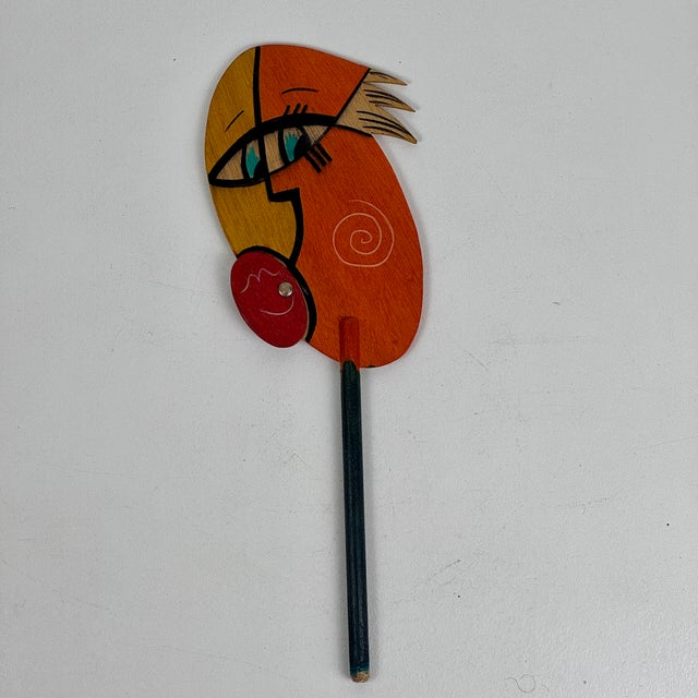 A whimsical vintage painted wood art face sculpture/mask on a stick. Stick it in a vase or on a wall and let it brighten...