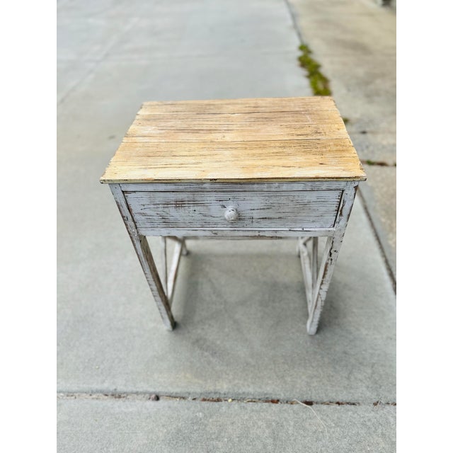 This wooden table is perfect for a side table or nightstand!The distressed white-painted base, featuring an X-brace design...