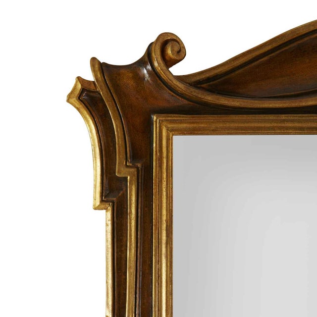 Shaped lacquered wood mirror, a Florentine shaped mirror in walnut-colored lacquer with gilded details, in good condition....