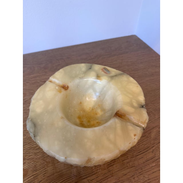 This mid-century hand-carved alabaster ashtray features beautiful natural stone veining in warm cream and honey tones....