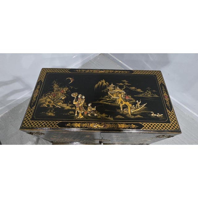 A very nice black chinoiserie two door low cupboard, single shelf, chinoiserie decoration to all sides, standing on squat...