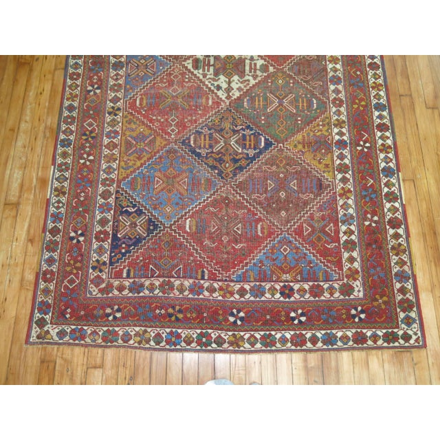 An early 20th century weathered textured appeal Persian Afshar rug with a colorful all-over diamond shaped design....