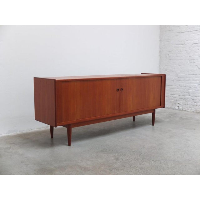 Very nice sideboard in the style of Arne Vodder produced in Denmark around 1960. This model features beautiful tambour...