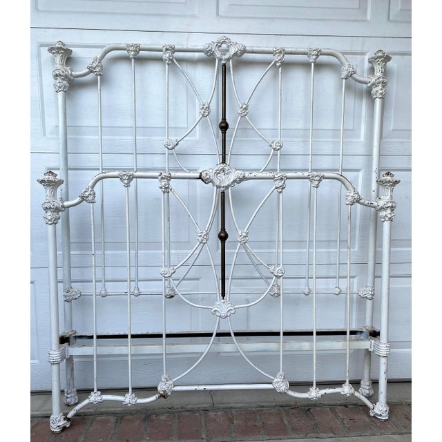 This antique 19th-century American-made iron and brass bed frame has a tall headboard, and a see-through crown casting,...