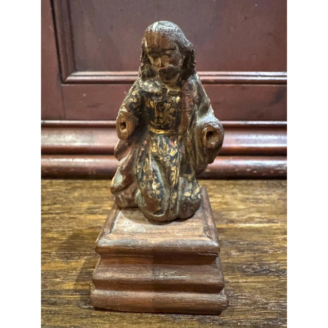 This 18th century polychromed wooden Santos depicts a man kneeling, he is missing both forearms. I am unsure of which...
