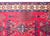 This vintage Anatolian Turkish rug features a vibrant red field adorned with intricate geometric and botanical motifs....