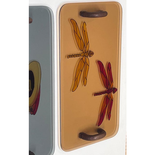 Artistic glass serving trays featuring Art Nouveau or stained glass-style decorations. The left tray features a blue-gray...