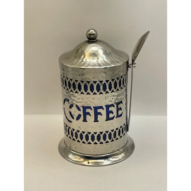 A lidded silverplate pierced coffee canister with spoon & blue translucent plastic liner. Set includes spoon and 1 canister.