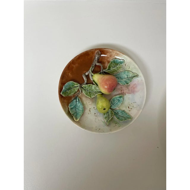 The product is a set of two French majolica Delonge trompe l'oeil circular pear dishes, one small and one larger. The...