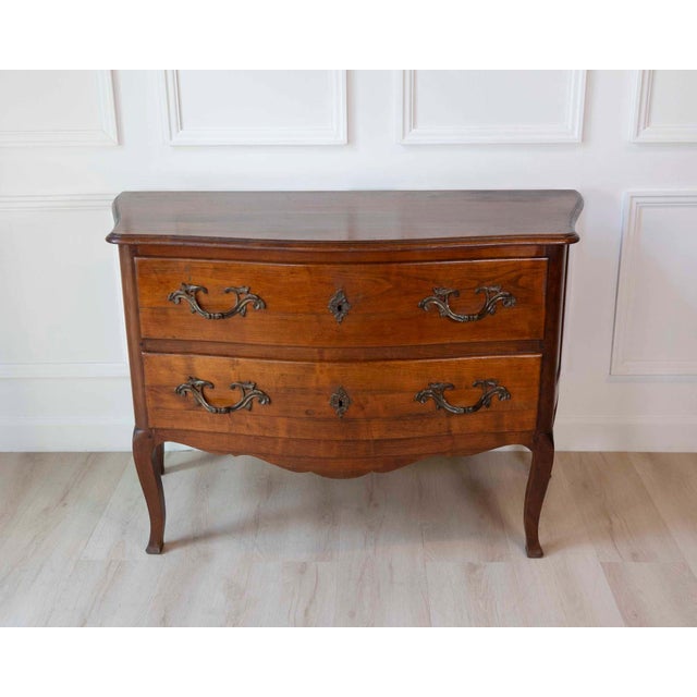 A beautiful antique Louis XV style commode crafted from solid walnut, featuring the graceful curves and refined...