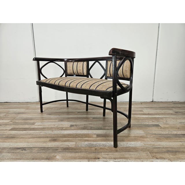 Early 20th-century bentwood sofa with padded seat and backrest decorated with brass studs. The sofa is attributed to...