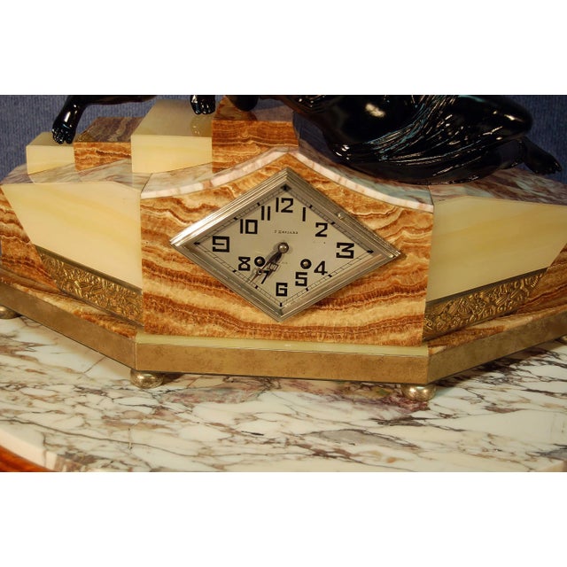 Very large pendulum Art Deco period around 1930, marble, onyx and antique frieze topped with gilded bronze with a black...