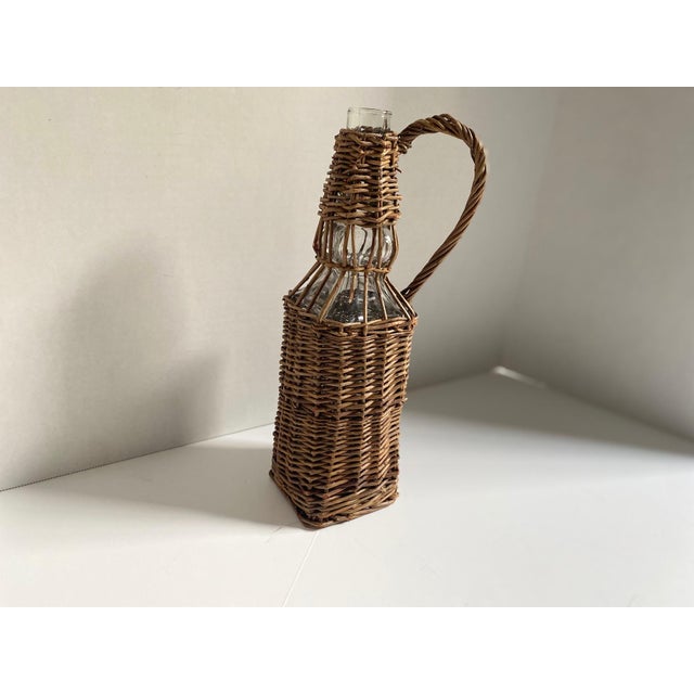 Charming vintage wicker-wrapped bottle in a classic French country style. Features a unique square shape with a sturdy,...