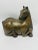 This piece is a sculpture of a reclining horse, crafted with a smooth, bronze-like finish. The stylized design highlights...